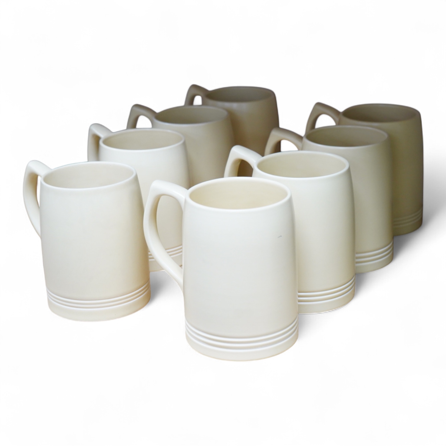 Keith Murray for Wedgwood, a set of eight straw glazed mugs, 12cm high